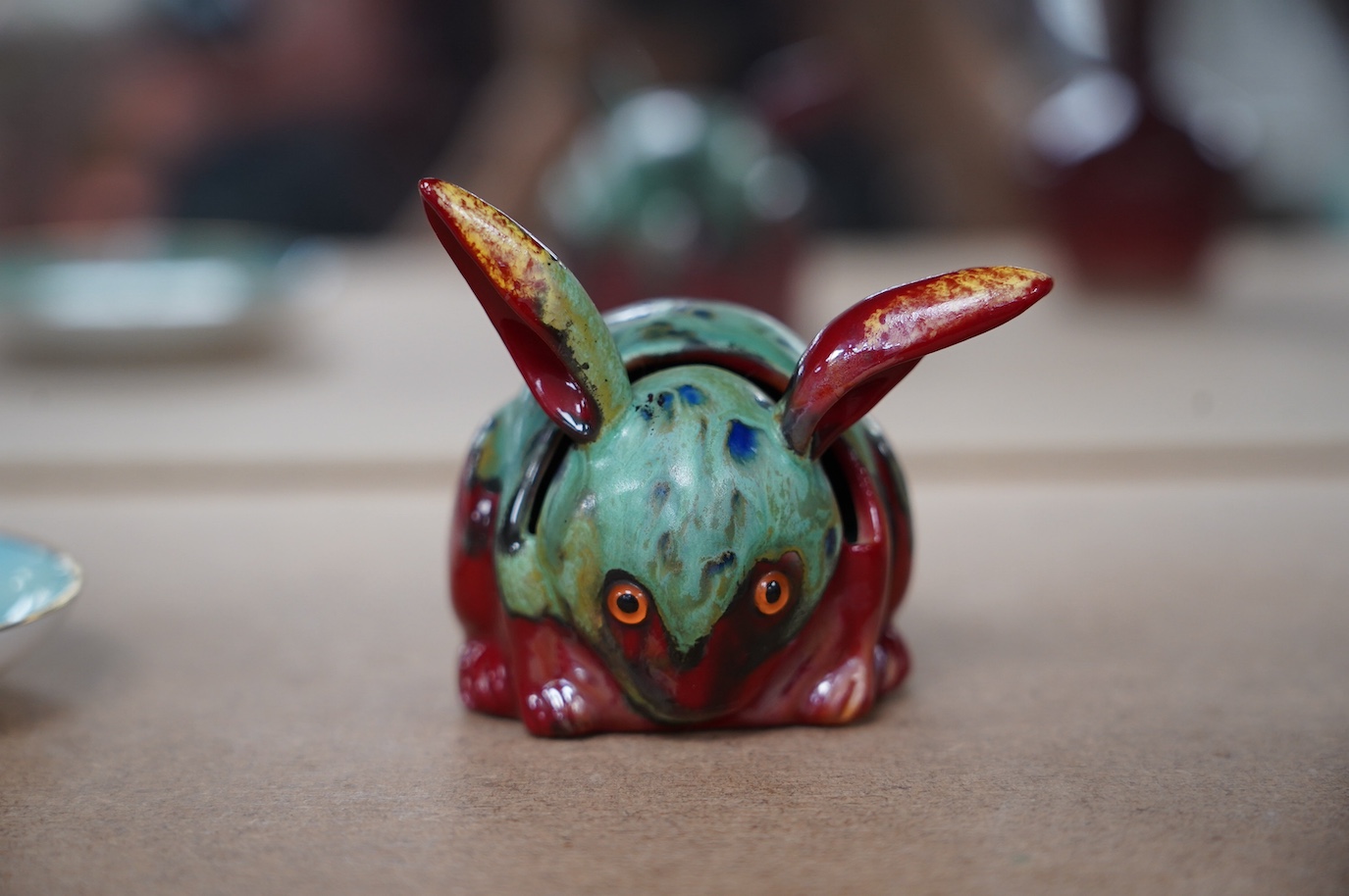 A Bernard Moore rabbit menu holder with inset orange glass eyes, c.1910, signed, 6cm high. Condition - good